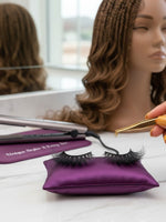 Unique Style 2 Envy Inc Chloe 3D handcrafted mink strip lashes on a purple satin pillow with gold tweezers.