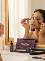 Woman applying Unique Style 2 Envy Inc Chloe 3D handcrafted mink strip lashes in front of a vanity mirror.
