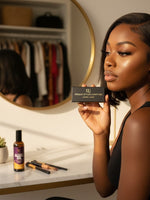Unique Style 2 Envy Inc Chloe 3D handcrafted mink strip lashes held by a woman in a vanity setting.